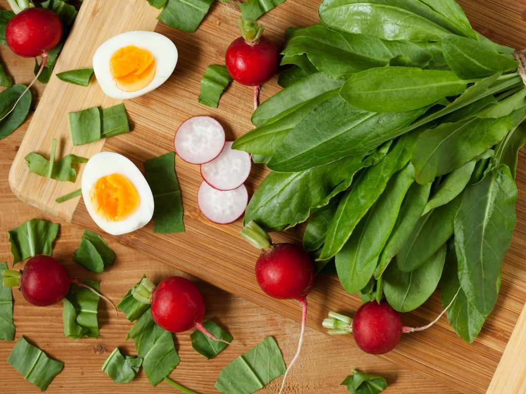 Sorrel on a cutting board with radishes and eggs